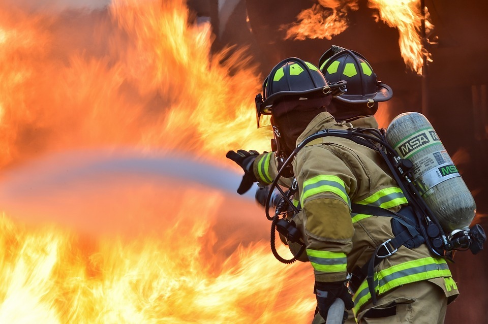 Twee brandweerlieden blussen grote brand