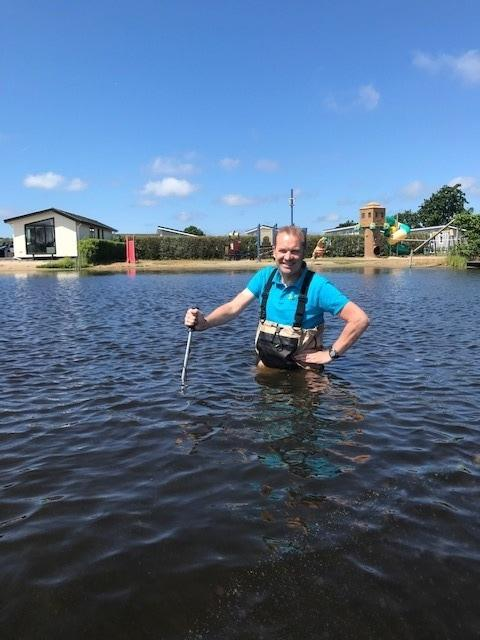 Inspecteur met waadpak in water